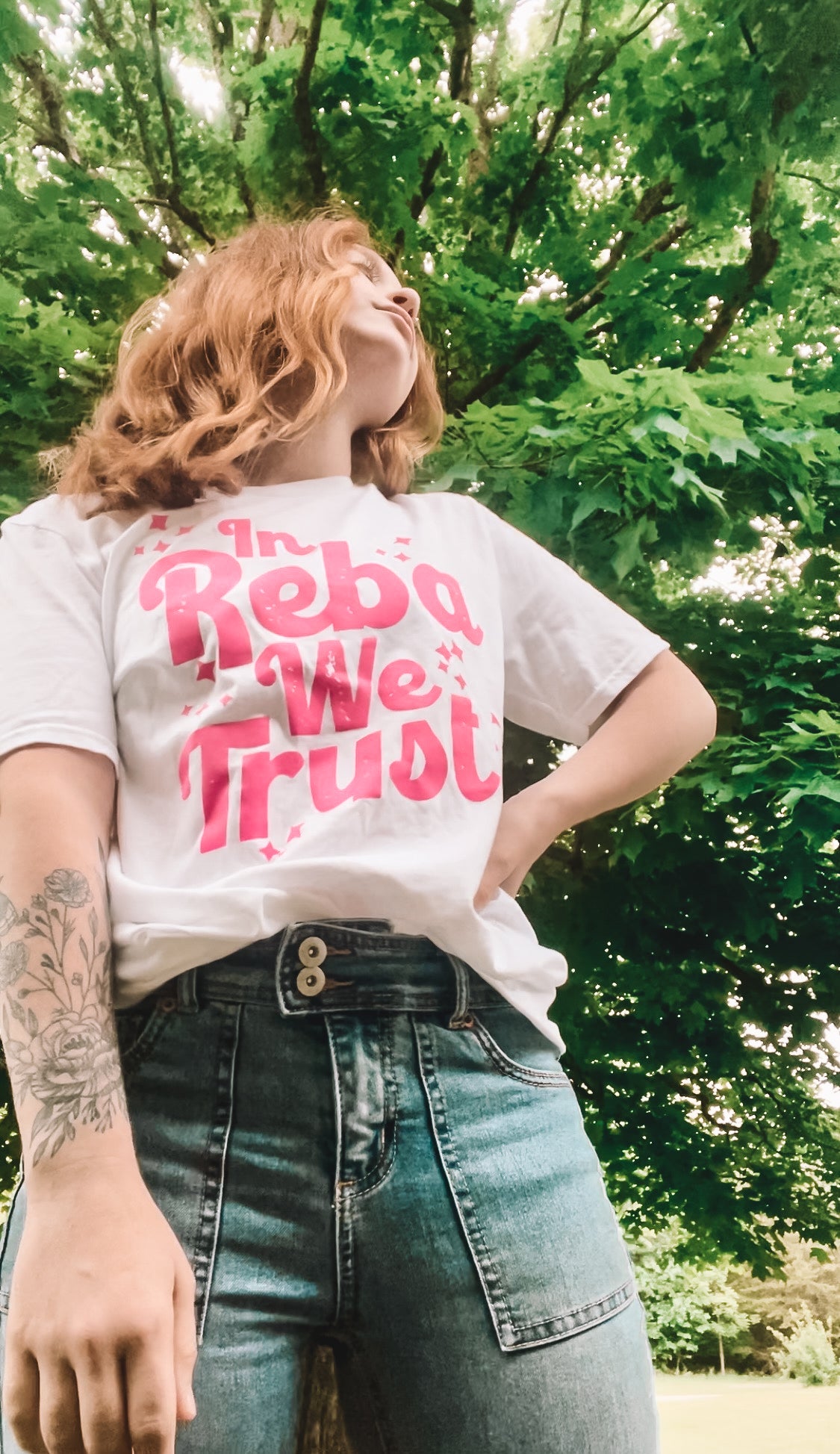 Font View of White Graphic Tee on Model with Pink Wording declaring "In Reba We Trust'